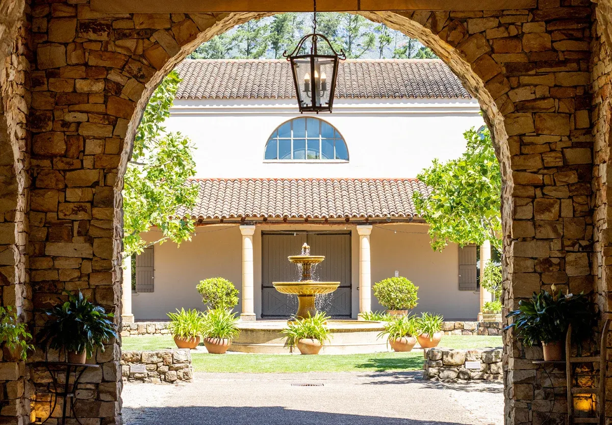 A courtyard fountain seen through an archway in South Africa's Waterford Wine Estate.